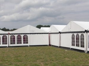 Et flot hvidt telt 6x15 meter fra Tommy Telt med tag og sorte tunger.