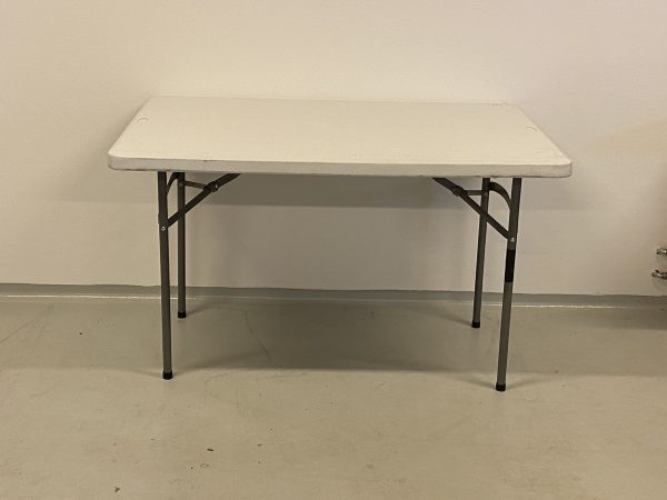 På billedet er et fint aflangt bord med hvid plastikplade og stålben.