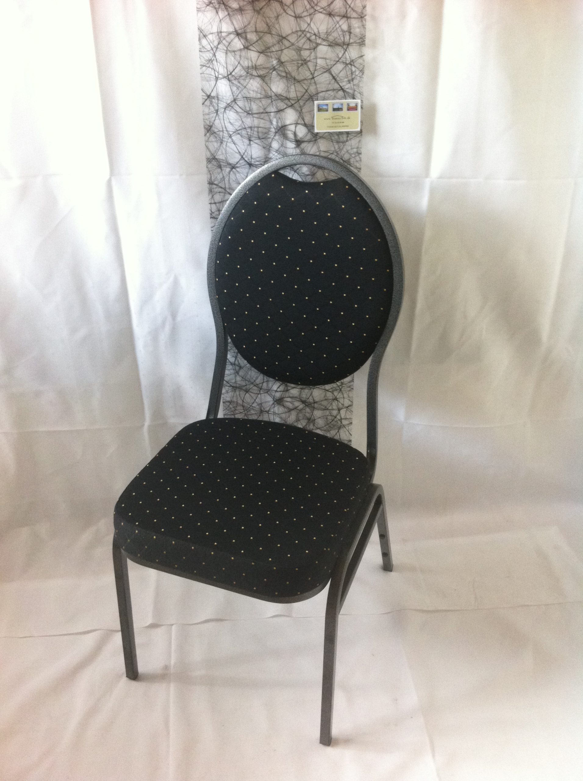 En flot banquetstol i sort overtræk med hvide prikker på. Et klassisk stilfuldt og yndigt mønster.
