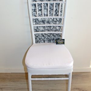 Du ser her en hvid bryllupsstol fra Tommy Telt. Stolen er overtrukket med hvid stof og har et fint mønstret ryglæn.